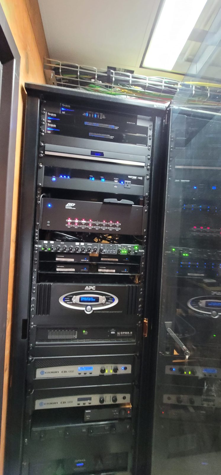 Detail view of country club AV equipment rack with amplifiers, processors, and managed network gear