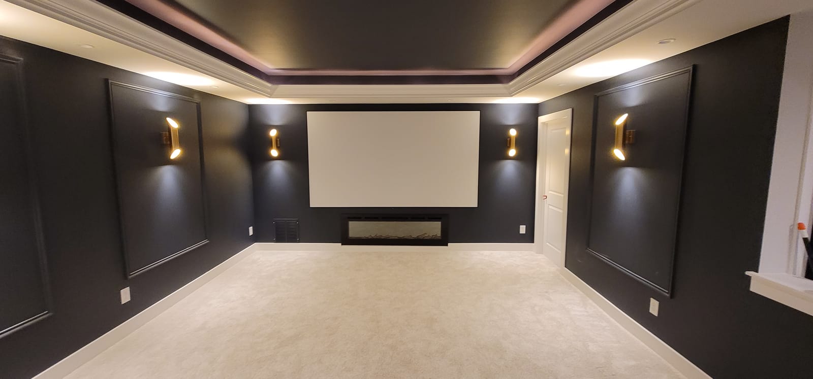 Custom home theater room with dark cinematic finishes and premium seating