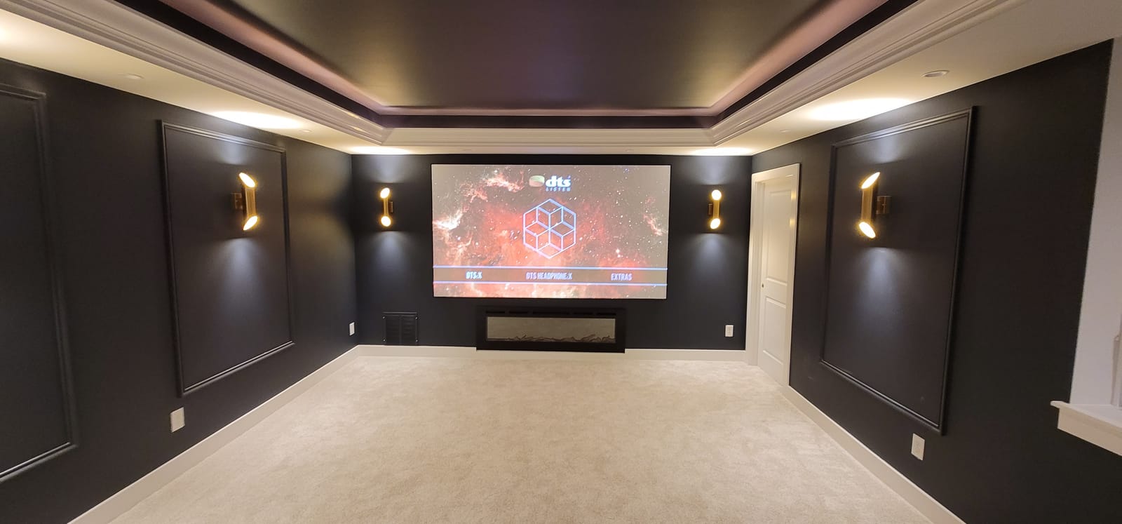 Dedicated home theater room with rows of theater-style seating and projection screen
