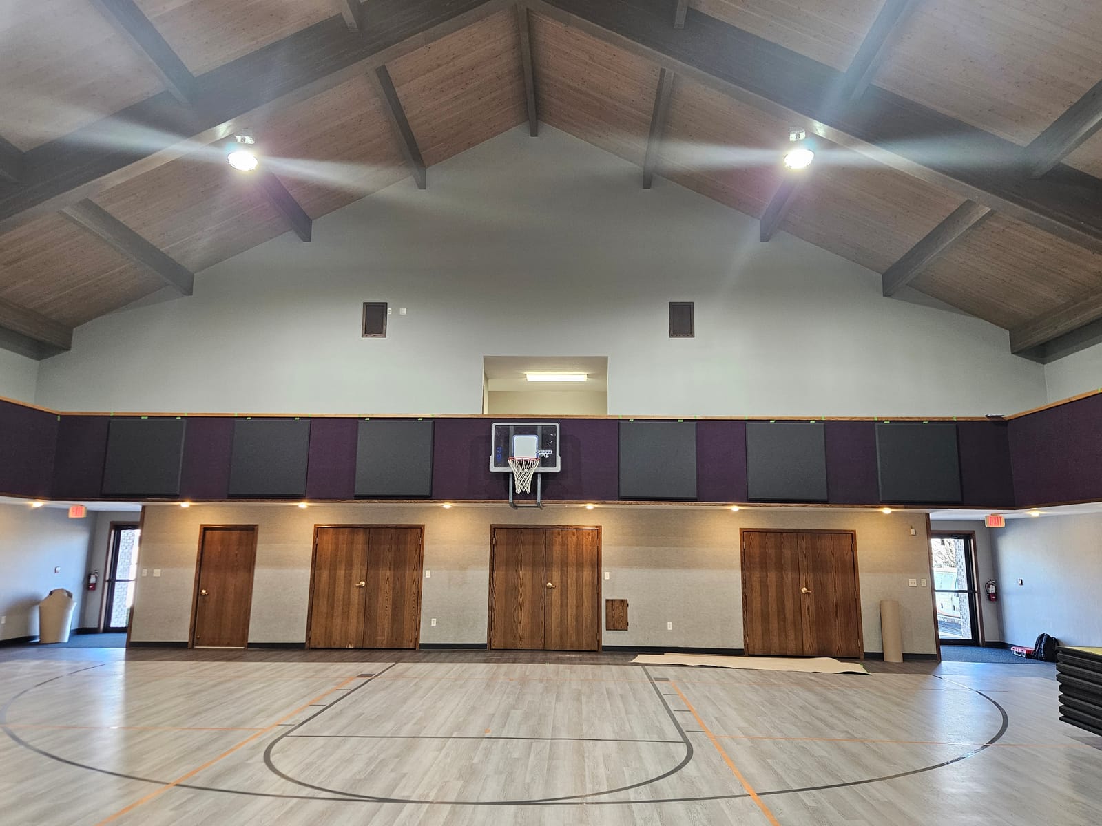 Gymnasium with custom acoustic absorber panels for sound control during events