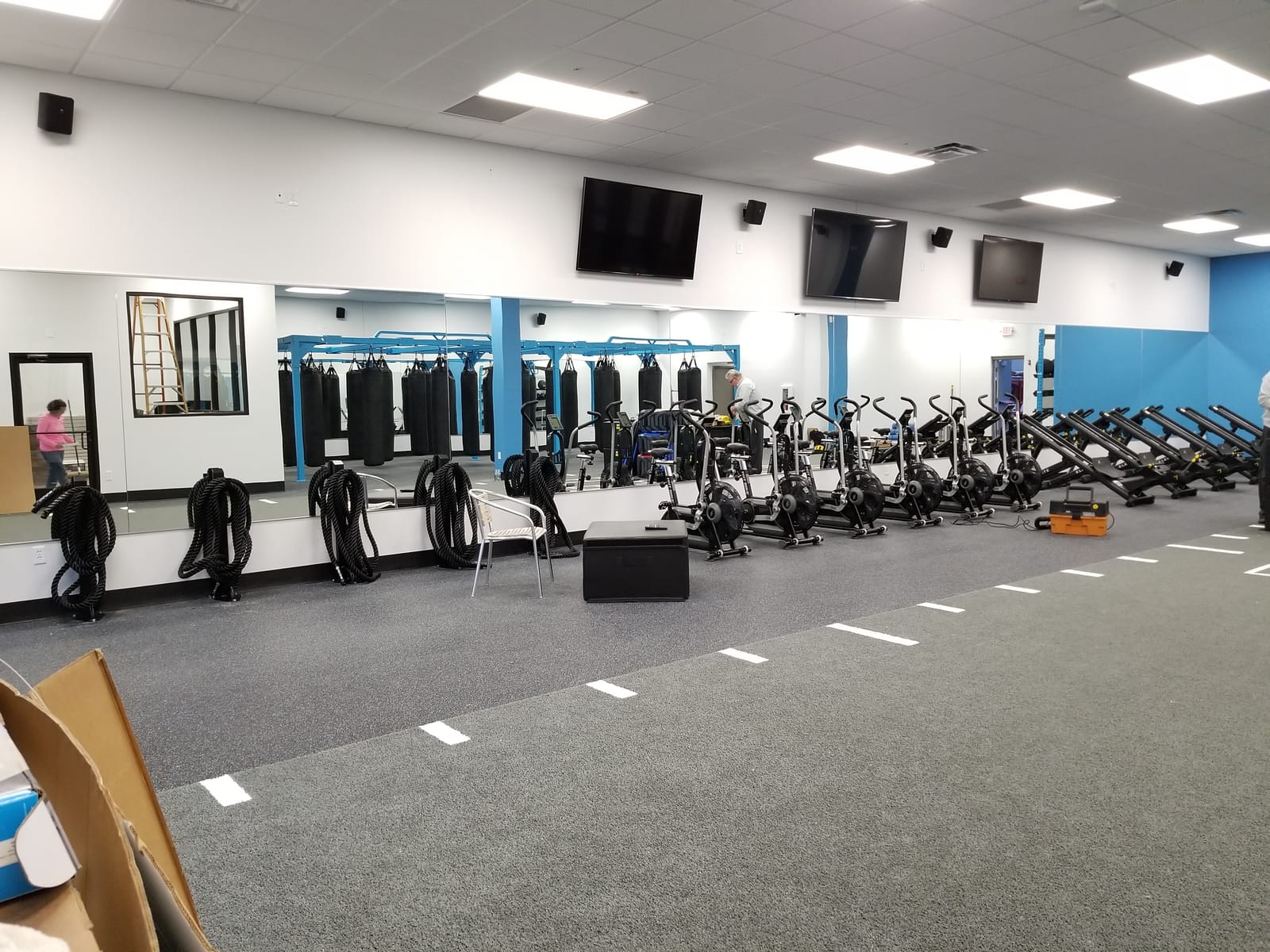 Wall-mounted televisions installed in a gymnasium space