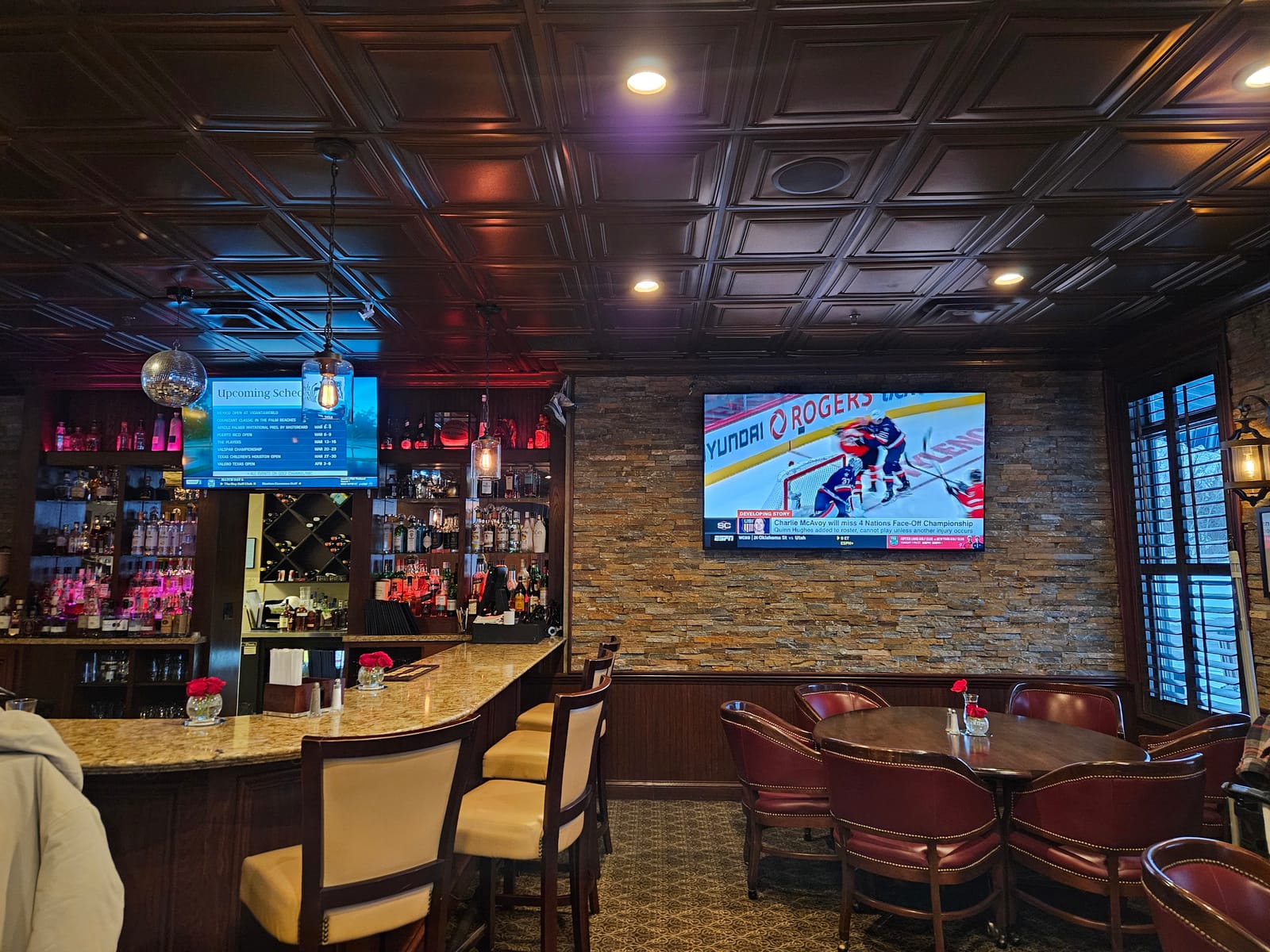 Harbour Trees member grille with multiple TVs, ceiling acoustic panels, and bar audio