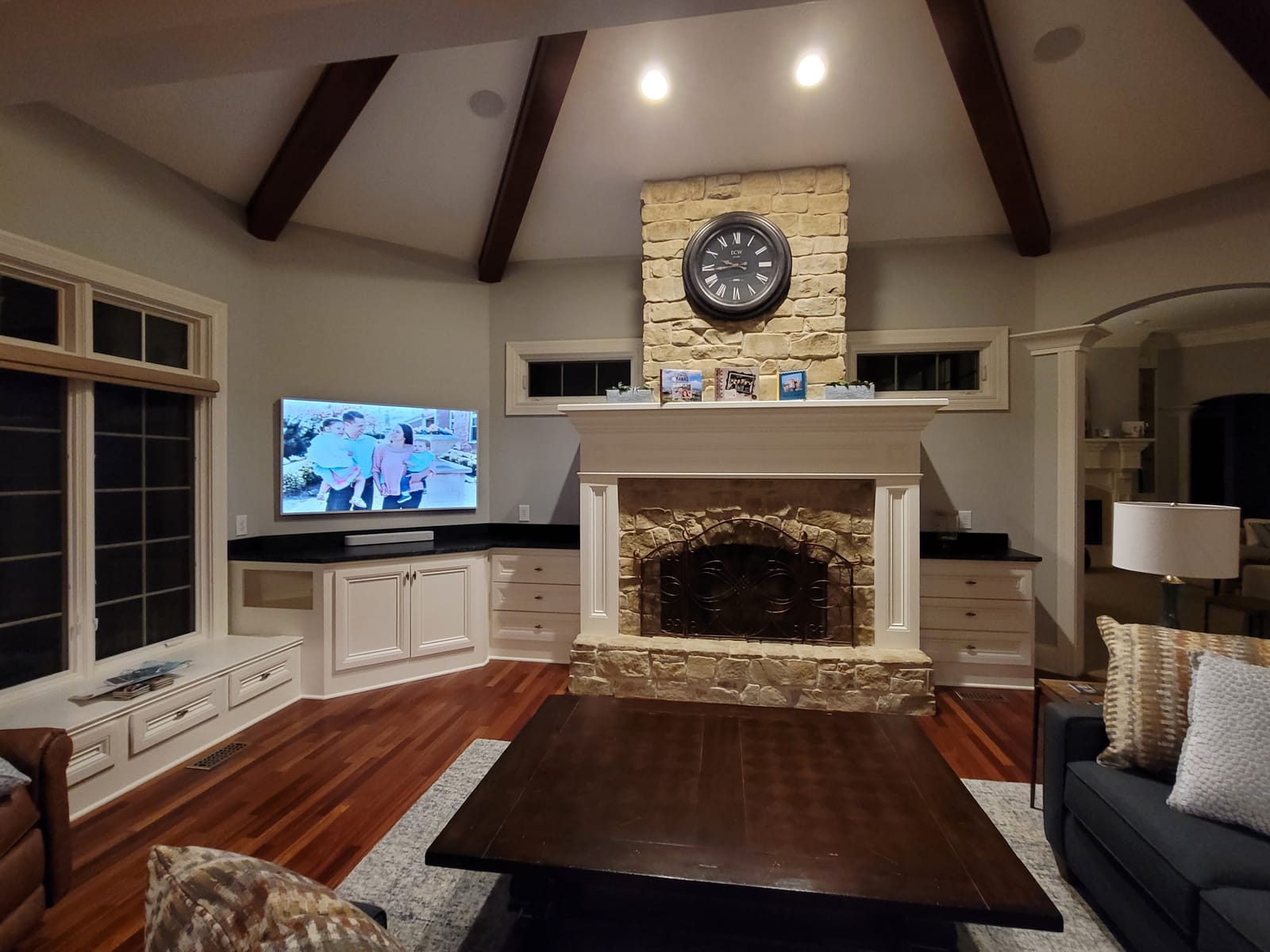 Family hearth room with mounted display and integrated audio above the fireplace