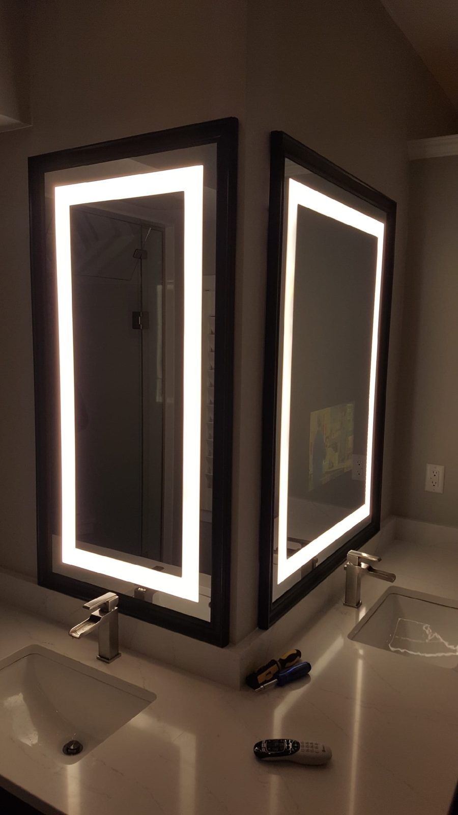 Twin LED-illuminated vanity mirrors installed by Noble A-V in a luxury bathroom