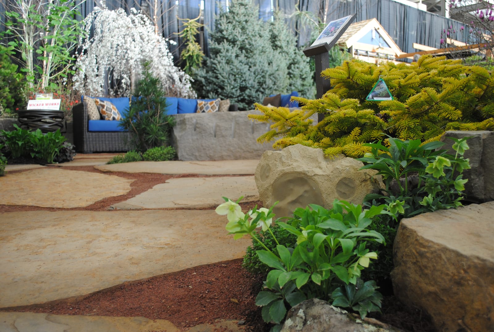 Outdoor patio with a concealed sandstone rock-shaped speaker amid landscape plantings