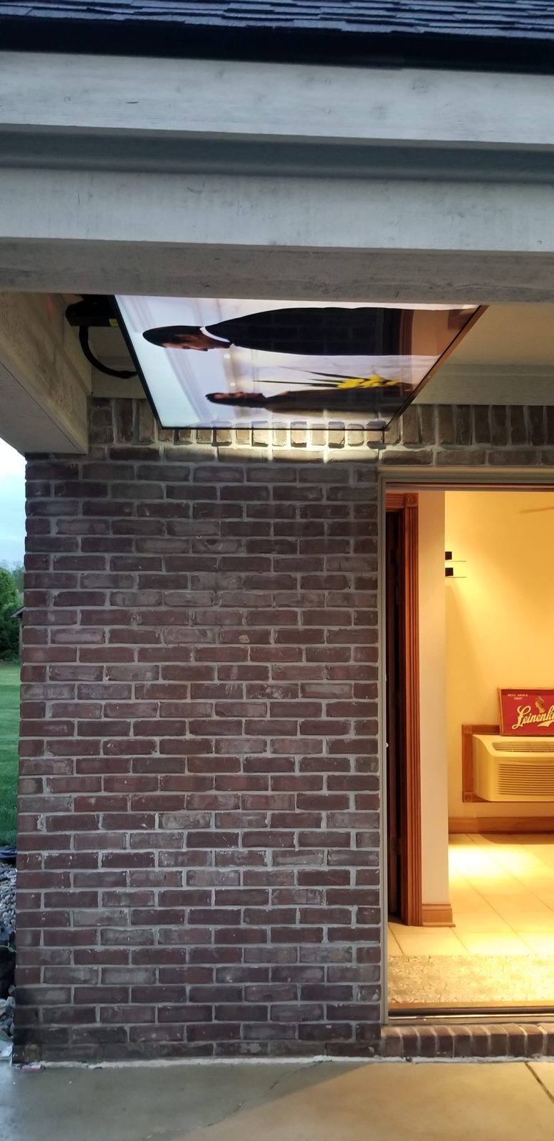 Outdoor television on a motorized articulating mount under a covered patio