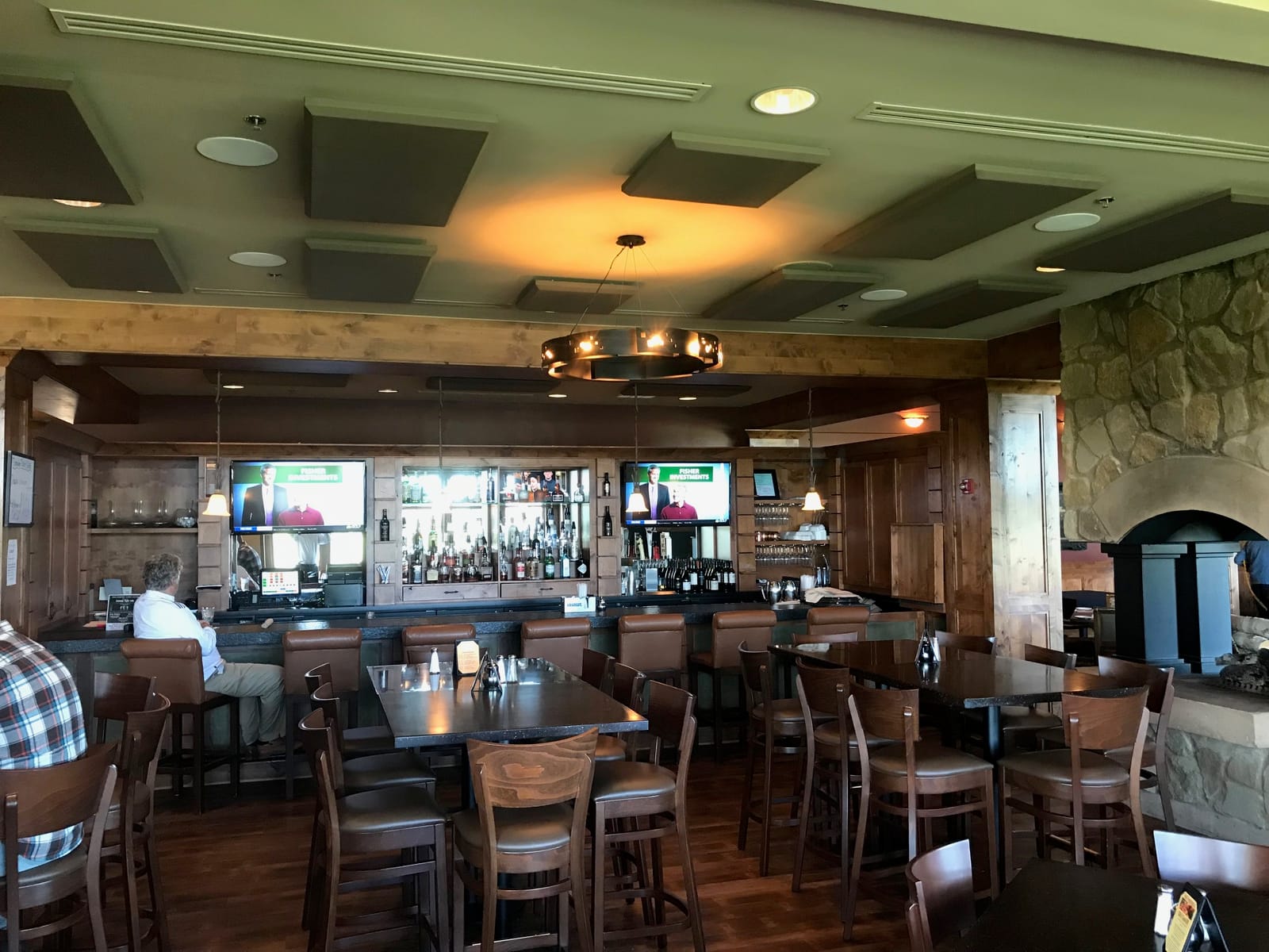 Restaurant bar with ceiling-mounted acoustic absorber panels, in-ceiling audio, and chandelier lighting