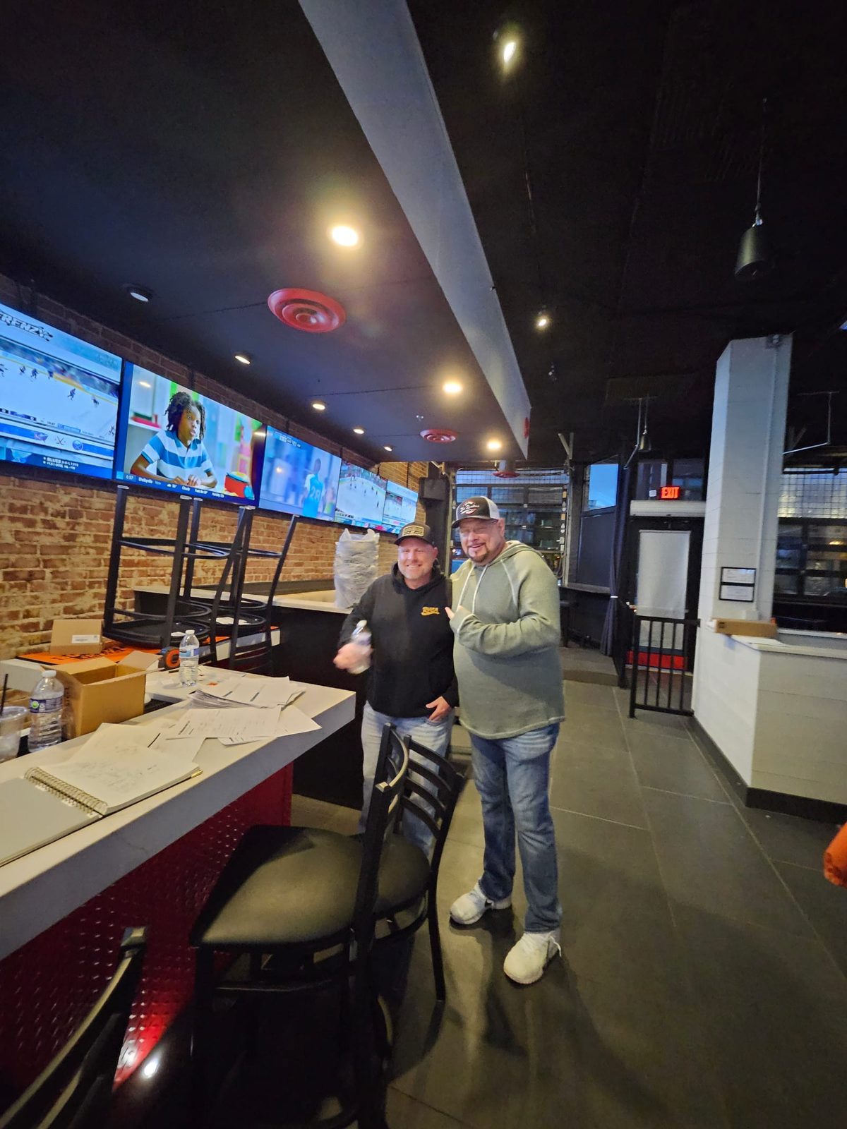 Tie Breakers sports bar interior with owners, multi-screen TV wall, and dining area