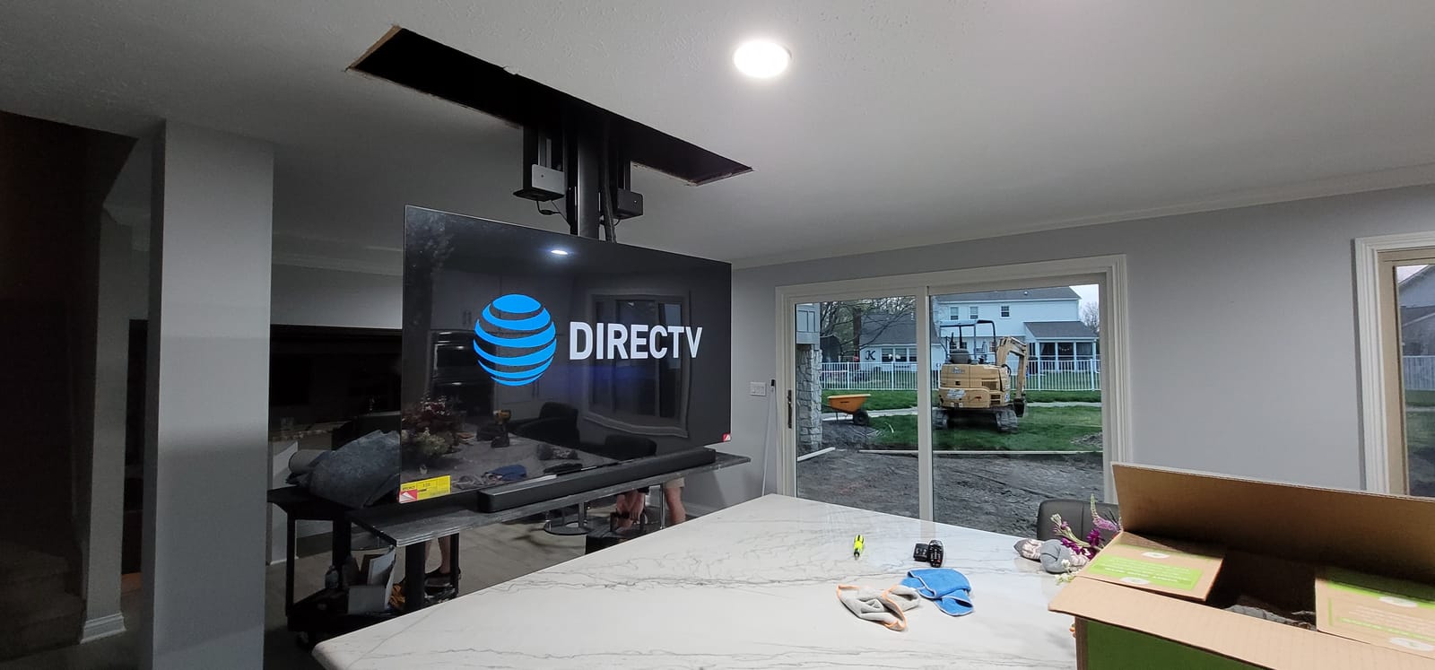 Television concealed in ceiling and lowered on a motorized drop-down mount for viewing