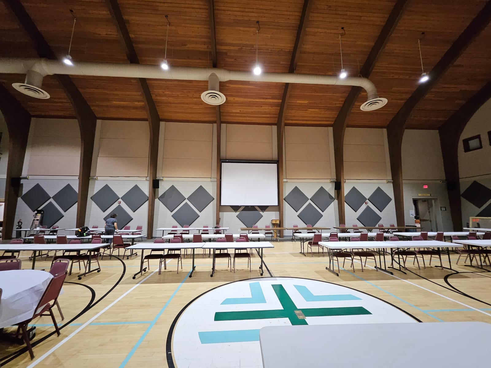 Multi-purpose gymnasium at a house of worship with custom acoustic absorber panels installed along high walls